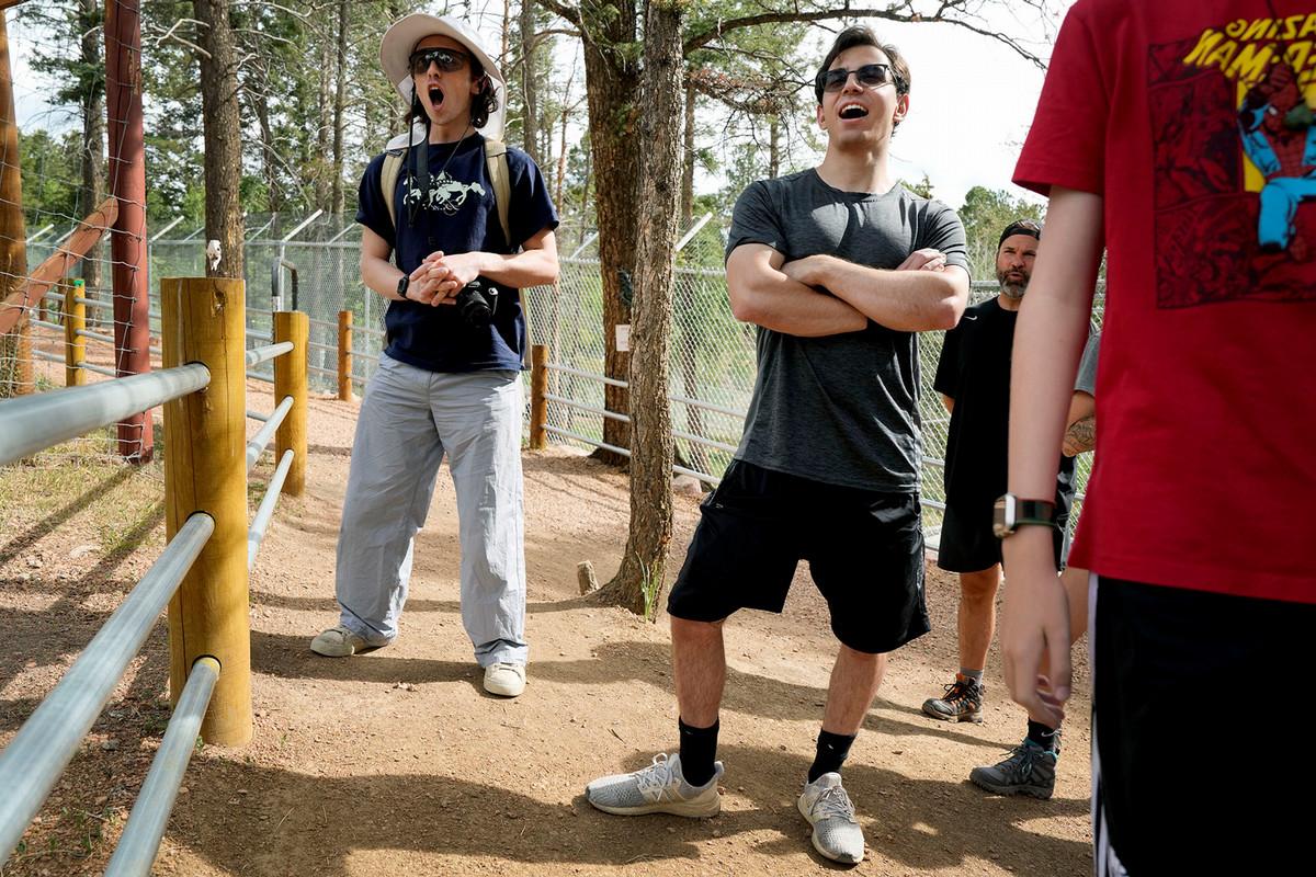 Clay Arnold '24, left to right, and Owen Cox '24 join in the group howl, where all participants are urged to howl and in response, the wolves throughout the Colorado Wolf and Wildlife Center howl back. Photo by Jamie Cotten / Colorado College